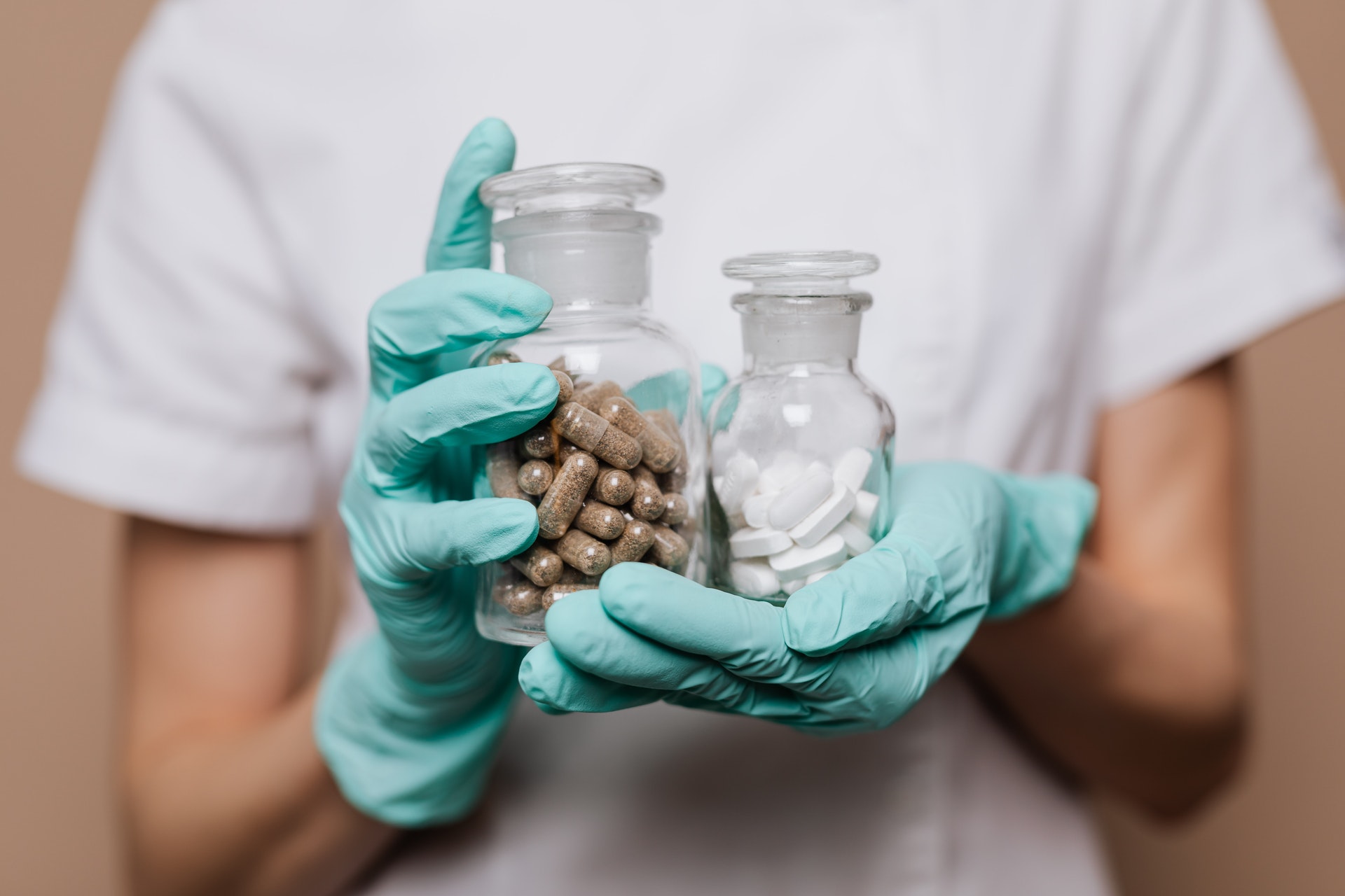 pharmacy technician holding jars of medication