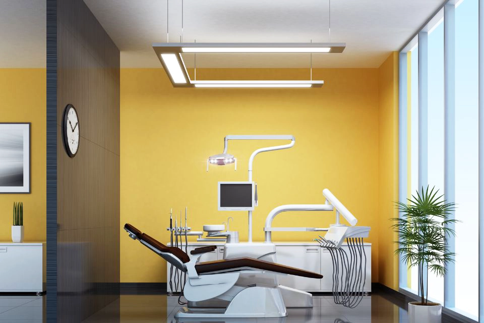 yellow wall with dental chair and computer in front of it